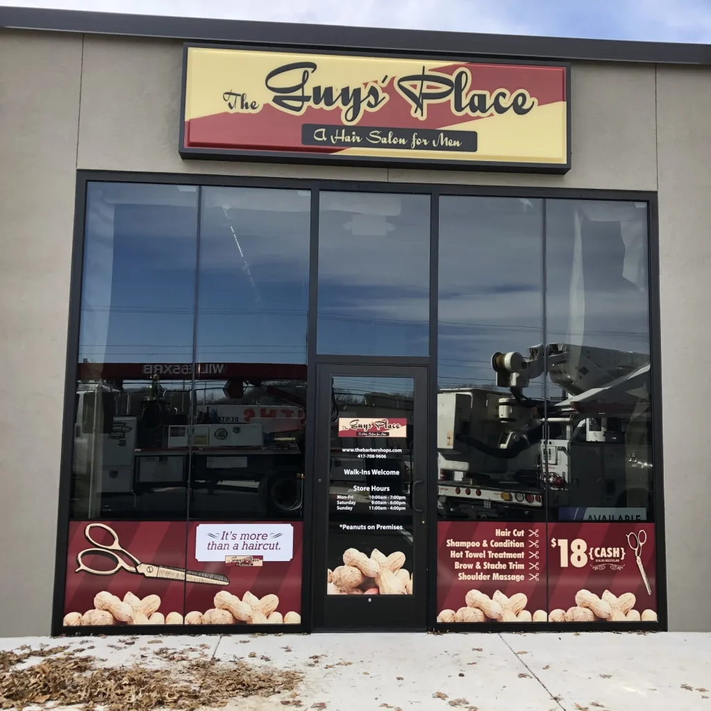 A cabinet sign installed above a barbershop