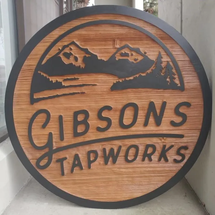 a round sandblasted sign depicting a brewery