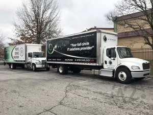 two moving trucks with full print vinyl graphics on the side of the truck box