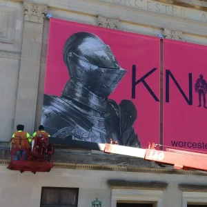 sign installers putting up large exterior banners printed with a large format printer